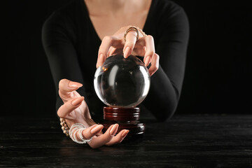 Fortune teller with crystal ball at table