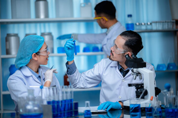 group of laboratory assistants checking blood, using microscope and doing test for bacteria