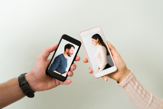 Hands holding smartphones with photos of a couple in love