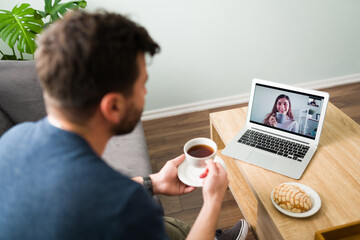 Rear view of a husband taking an afternoon break and video calling his wife