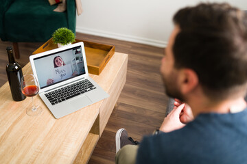 Rear view of a couple missing each other on a video chat