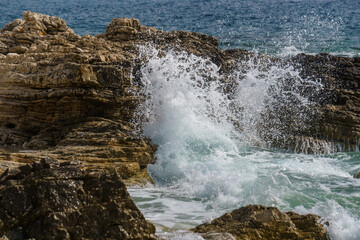 wave crash against rocks and splashes on croatian coastline