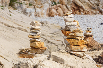 Fototapeta na wymiar cairn of yellow stones at rocky beach