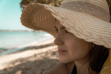 rostro de mujer con sobrero de playa frente al mar