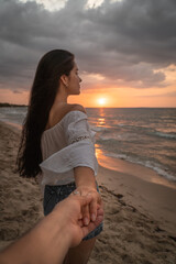 mujer en la playa admirando el atardecer frente al mar