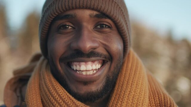Extreme close-up portrait of african american man in winter clothing smiling to camera standing outsideExtreme close-up portrait of african american man in winter clothing smiling to camera standing o