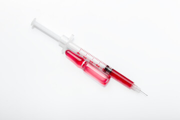 glass ampoule with red virus vaccine with syringe with drug dose isolated medical objects.