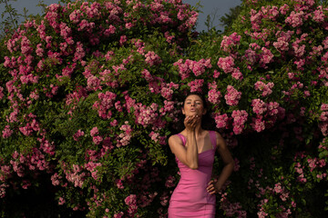 Fashion photo of a beautiful elegant young woman. Flowers background. Sensual. Summer time. Happy day. 