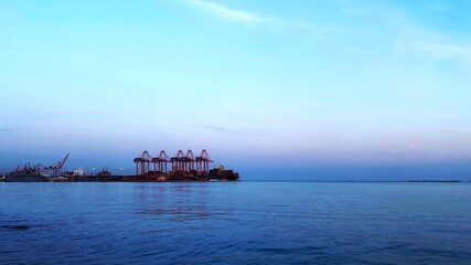 A view of a commercial port with a beautiful sky and sea