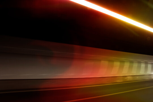 Fast moving light in tunnel. Dynamic and Abstract background with black space created in camera with lines of red and white spectrums of light crossing to create a sense of movement. Stock Photo.