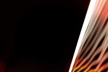 Abstract background created in camera with lines of light, black space, white streaks on the right side. Stock Photo.