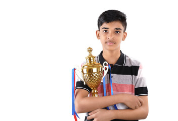 Indian school boy holding a golden trophy cup