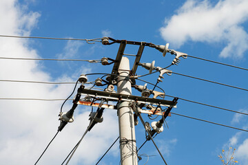 Telephone poles under blue sky and white clouds
