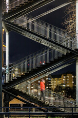 Stockholm, Sweden A person descends an outdoor staircase from Liljeholmsbron, or Liljeholmen bridge.