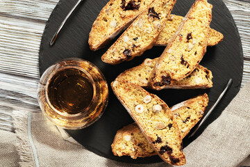 Sweet cantuccini biscuits and sweet wine. Homemade Italian biscotti cookies on woden table.