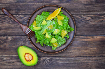 fresh summer homemade salad of vegetables and fruits, orange, lettuce, avocado and sesame seeds, healthy food, organic, vegetarian eco health and immunity products