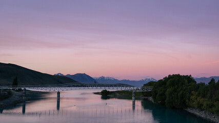 Dramatic twilight of Lake Tekapo new bridge with the snowy peaks behind. New Zealand