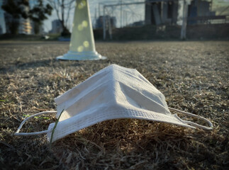 A white face mask on a grass in a football training field during sunrise