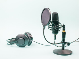 Condenser microphone and wired headphones on a blue background.