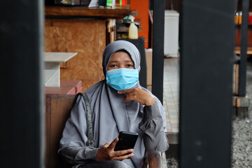 Fototapeta na wymiar Beautiful women wearing mask while relaxing in a cool cafe, selective focus and noise image