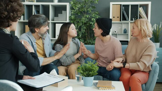 Teenagers brother and sister are fighting with each other pushing parents and yelling during session with phychologist. Family problem and psychology concept.
