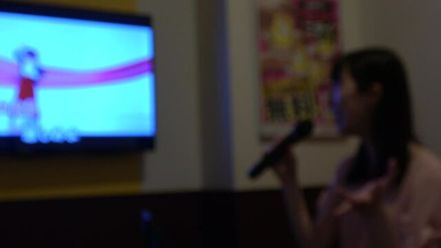 ぼかし背景素材: カラオケ店で歌う若い女性  ひとりカラオケ 4K
