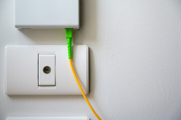 TV socket available on the white wall under fiber optic internet wall box.