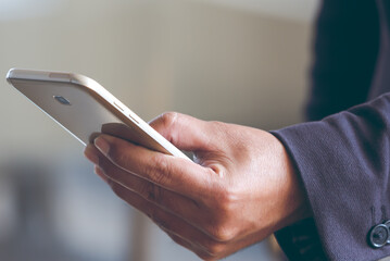 Close up young man hand holding using smartphone