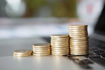 A row of increasing euro coins on a laptop keyboard