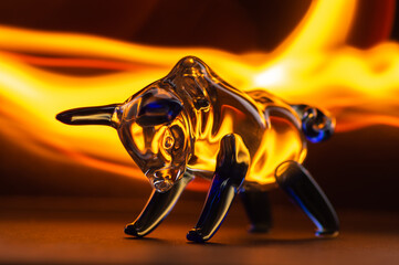 bull figurine on a black background in the glare of fire