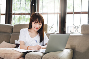 Young adult asian woman work and study at home on virus pandemic social issuse.