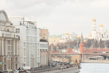 Moscow, Russia.  Houses on river embankment. The Kremlin wall (east and south side), towers, temples. Bolshoy Moskvoretsky bridge.