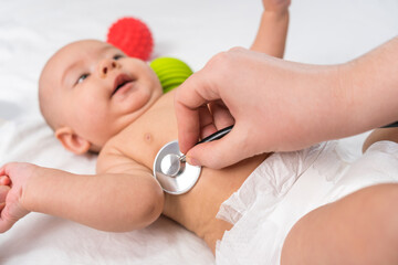 Checking the health of the newborn. Hands with a stethoscope. Selective focus