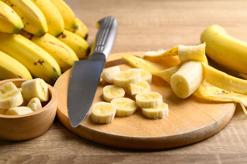 Sliced ripe banana fruit on wooden cutting board preparing for cooking