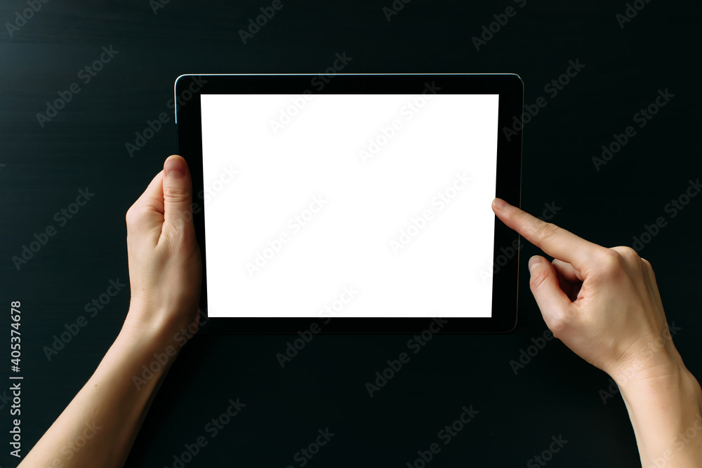 Wall mural tablet computer with white blank screen in hands isolated on black background. holding and pointing 