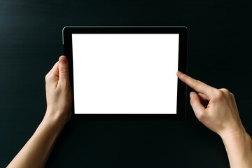 Tablet computer with white blank screen in hands isolated on black background. Holding and pointing to empty screen on digital tablet. Copy space.