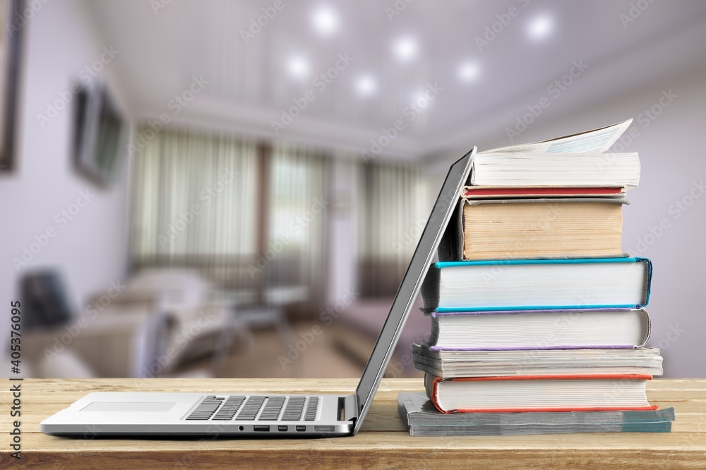 Poster stack of books with a modern laptop on the table