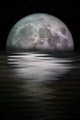 Blue moon rising out of the sea. Elements of this image furnished by NASA.