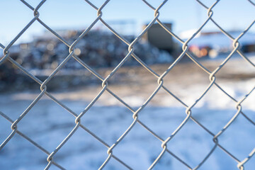 Chain link fence with Garbage recycle dump behind it