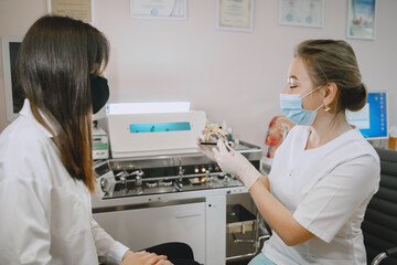 Woman patient in the medical office. Doctor in medical mask.