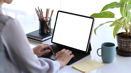 Cropped shot of young female designer working on tablet computer at creative workstation.