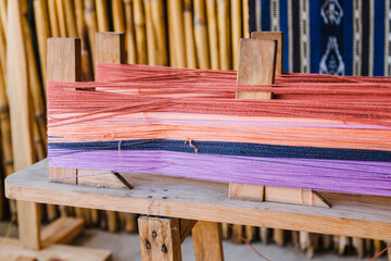 Colored threads put on the loom to weave - wooden loom that separates the threads to make local fabrics - typical fabrics in rural Guatemala