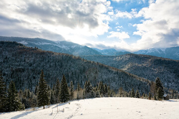 Beautiful winter landscape with mountains and trees covered with fresh snow and the sun shining
