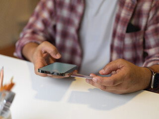Businessman using smartphone on white table in office room