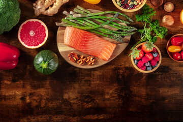 Healthy food, shot from the top with a place for text. Salmon, grapefruit, asparagus and other superfoods on a dark rustic wooden background