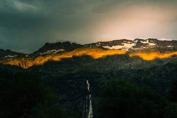 un rayon de soleil sur une montagne et une chute d'eau. Un coucher de soleil sur une montagne et une cascade d'eau.