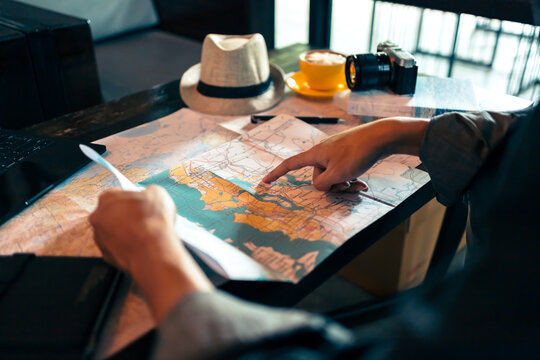 Tourist planning vacation with map and other travel accessories on the table. Travel, holiday, vocation concept.