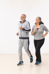 A SENIOR COUPLE JOGGING TOGETHER HAPPILY	