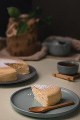 Vertical low angle view of a Japanese cheesecake with tea sets, -image
