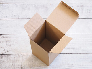 empty opened cardboard box on wooden vintage table.